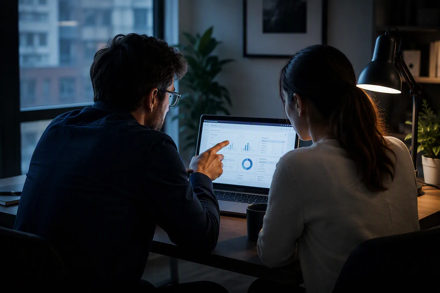 Two colleagues reviewing a candidate profile together on a laptop